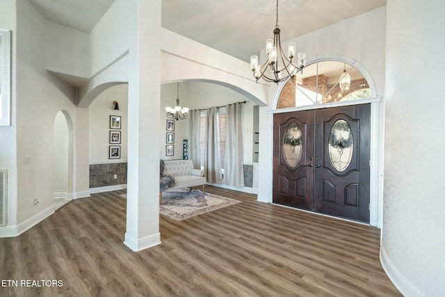 entryway with dark hardwood / wood-style flooring, a high ceiling, and an inviting chandelier