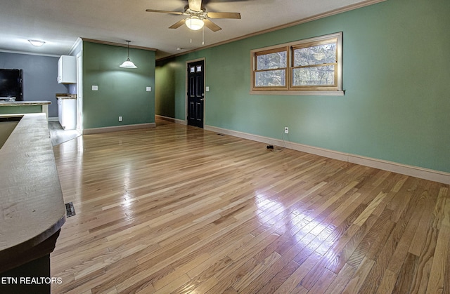 unfurnished living room with ceiling fan, light hardwood / wood-style flooring, and ornamental molding