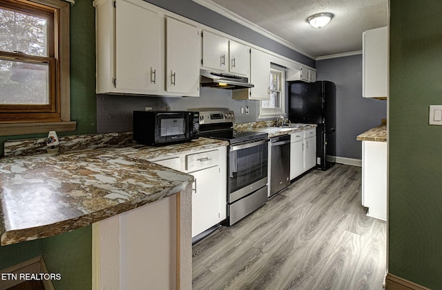 kitchen featuring black appliances, white cabinets, crown molding, and a wealth of natural light