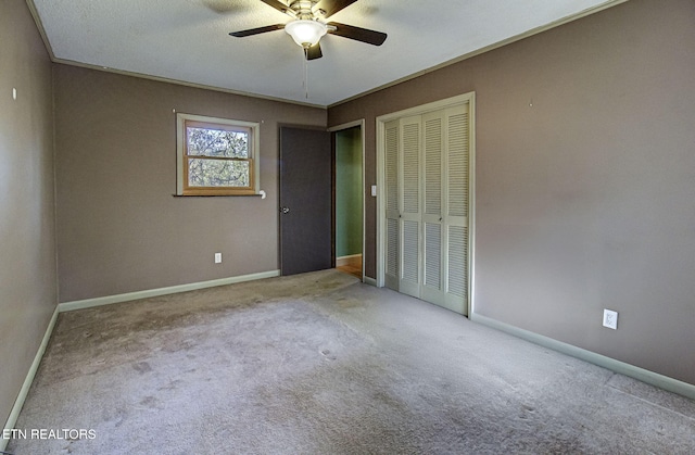 carpeted empty room featuring a textured ceiling, ceiling fan, and ornamental molding