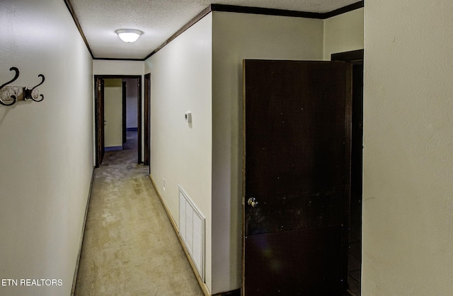 hall featuring light carpet, crown molding, and a textured ceiling