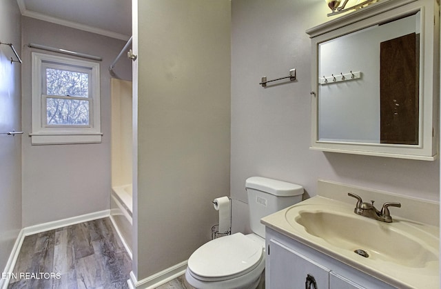 full bathroom with hardwood / wood-style floors, vanity, toilet, ornamental molding, and shower / bathtub combination