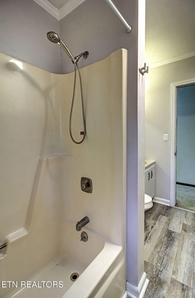 bathroom featuring toilet, ornamental molding, tub / shower combination, and hardwood / wood-style flooring