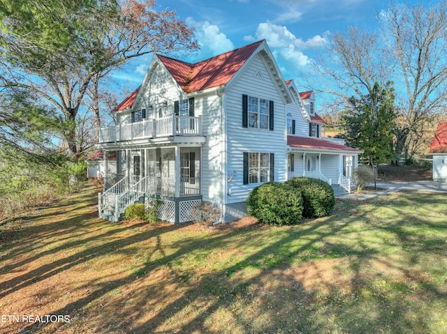 view of front facade with a balcony and a front yard