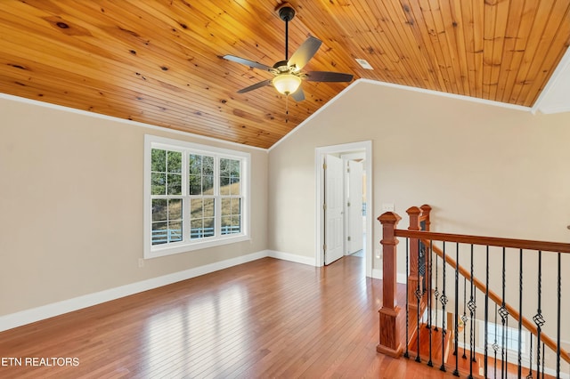 empty room with hardwood / wood-style floors, wooden ceiling, crown molding, vaulted ceiling, and ceiling fan