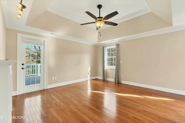 unfurnished room with hardwood / wood-style floors, crown molding, and a tray ceiling