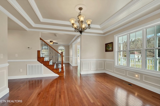 interior space with hardwood / wood-style floors, a tray ceiling, a wealth of natural light, and crown molding