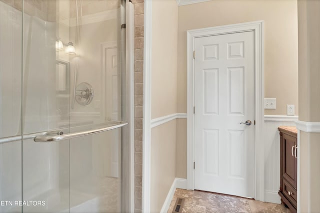 bathroom with vanity, an enclosed shower, and crown molding