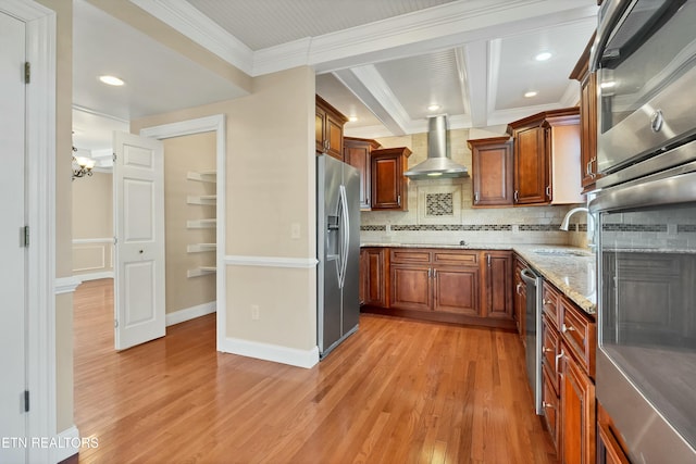 kitchen with sink, stainless steel appliances, wall chimney range hood, light wood-type flooring, and ornamental molding