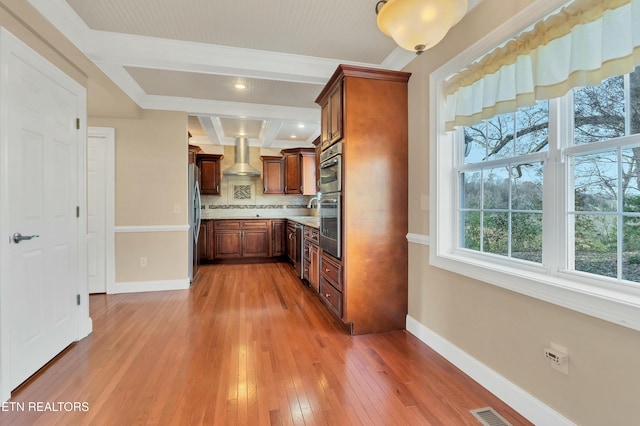 kitchen featuring tasteful backsplash, wall chimney range hood, beam ceiling, wood-type flooring, and stainless steel refrigerator