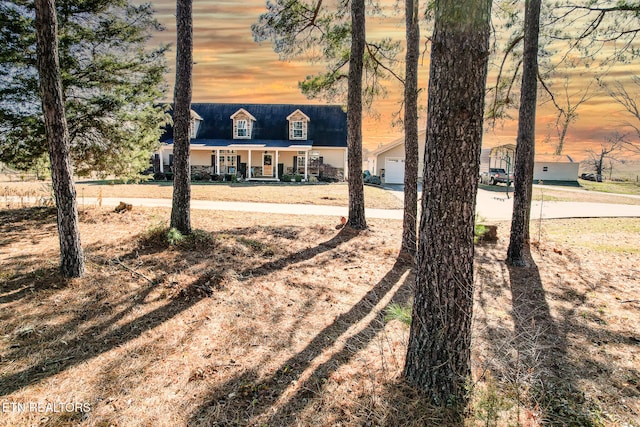 view of front of home with covered porch, an outdoor structure, and a garage