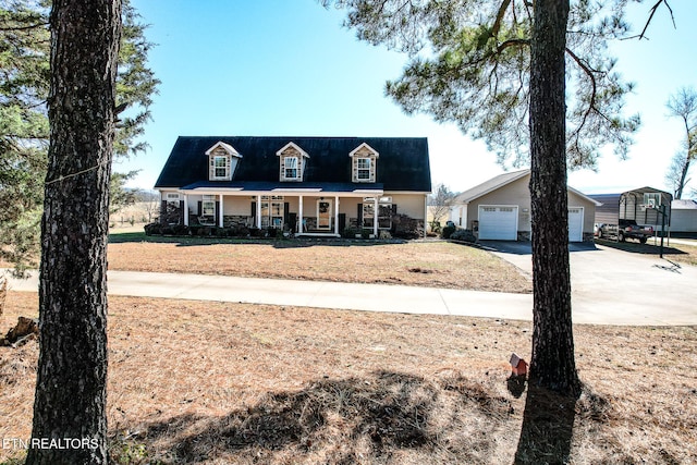 cape cod house featuring a garage, covered porch, and an outbuilding