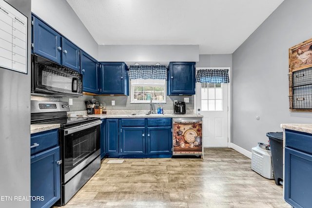 kitchen featuring light hardwood / wood-style floors, blue cabinetry, appliances with stainless steel finishes, and tasteful backsplash