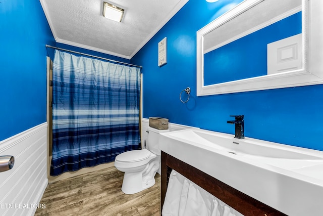 bathroom featuring vanity, a textured ceiling, crown molding, hardwood / wood-style floors, and toilet