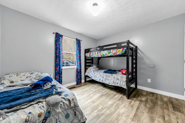 bedroom with a textured ceiling and hardwood / wood-style flooring