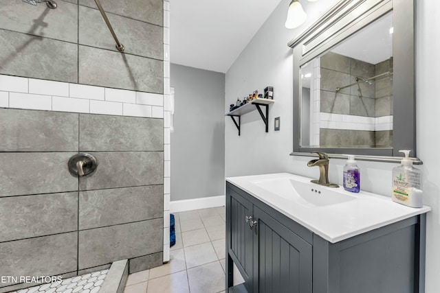 bathroom with tile patterned flooring, vanity, and a tile shower