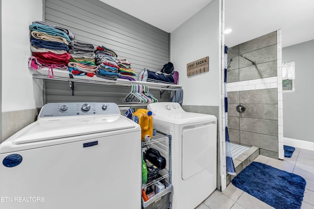 laundry area featuring washing machine and dryer and light tile patterned flooring