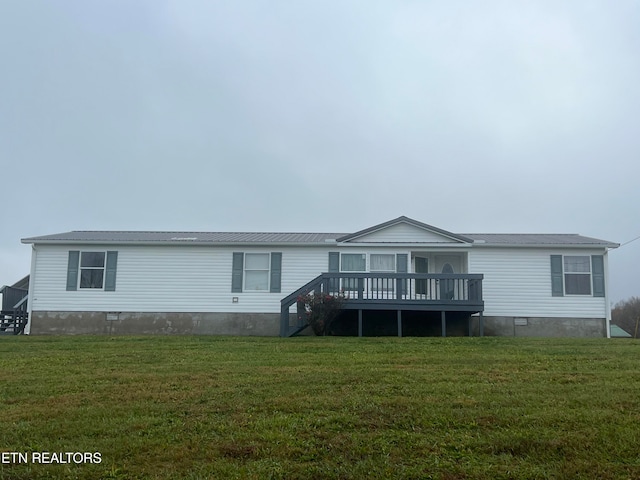 back of property with a lawn and a wooden deck