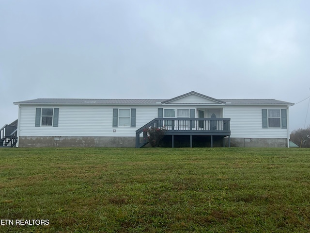 rear view of property with a lawn and a deck