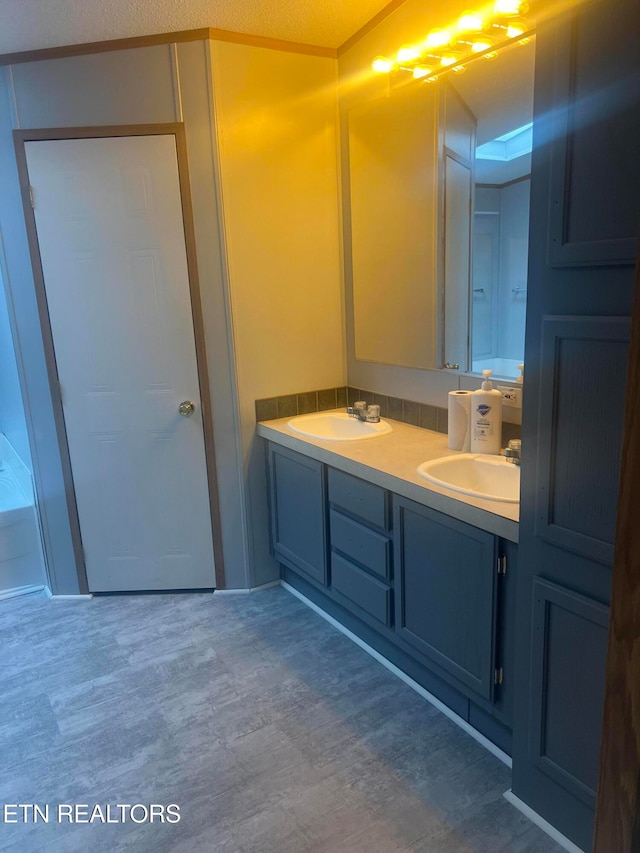 bathroom featuring hardwood / wood-style flooring, vanity, and a textured ceiling