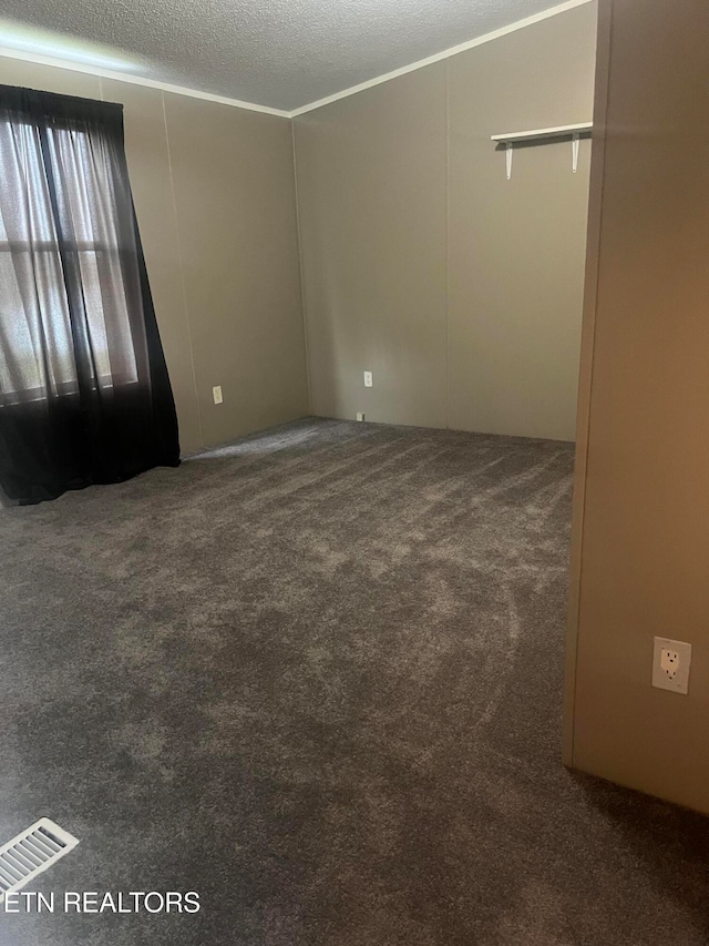 carpeted empty room with a textured ceiling