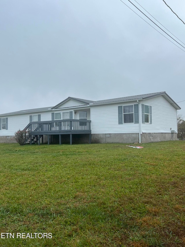 rear view of property featuring a wooden deck and a yard