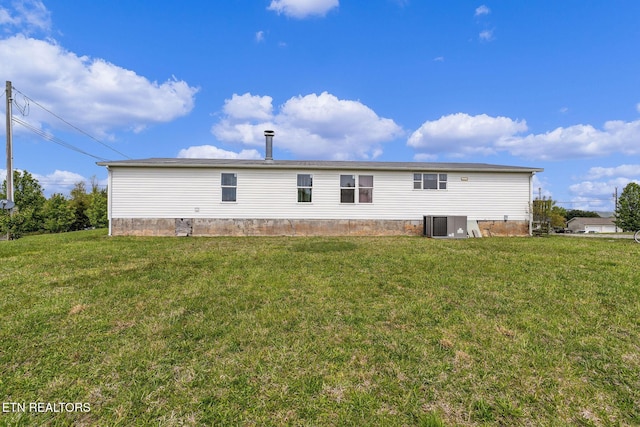 back of house featuring a lawn and central AC