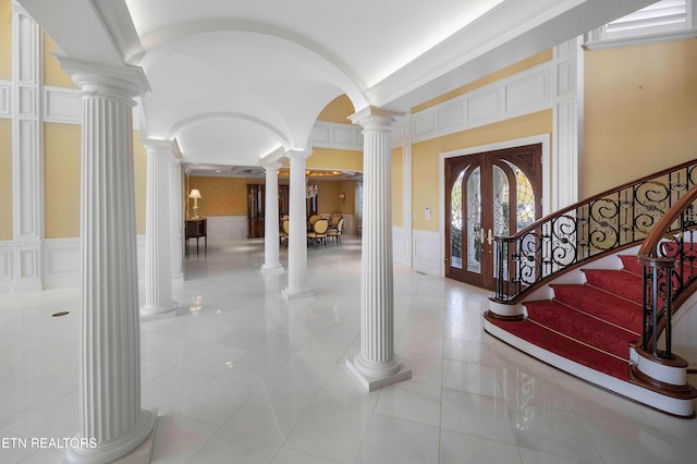 tiled foyer with french doors and ornamental molding