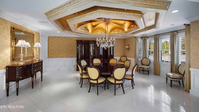 dining area with a raised ceiling, ornamental molding, and an inviting chandelier