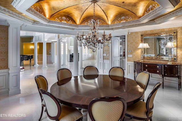 dining space featuring ornate columns, a chandelier, lofted ceiling, and ornamental molding