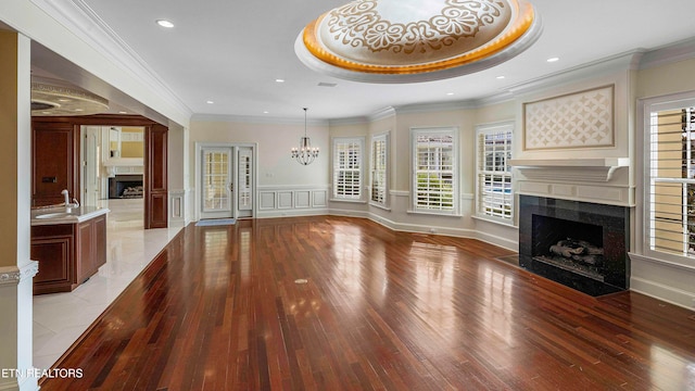 unfurnished living room featuring ornamental molding, light hardwood / wood-style floors, and a healthy amount of sunlight