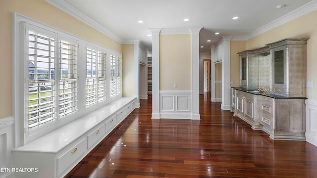 corridor featuring a healthy amount of sunlight, dark hardwood / wood-style flooring, and ornamental molding