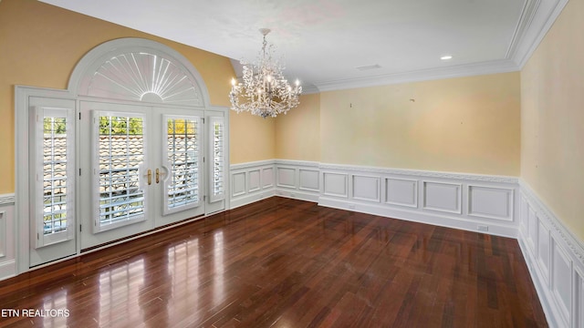 spare room with a chandelier, french doors, dark hardwood / wood-style flooring, and crown molding