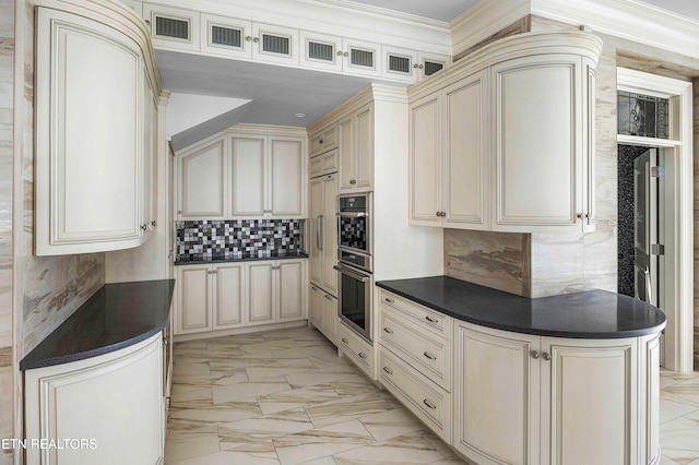 kitchen with double oven, decorative backsplash, cream cabinets, and crown molding