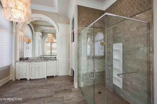 bathroom featuring vanity, an enclosed shower, ornamental molding, and a chandelier