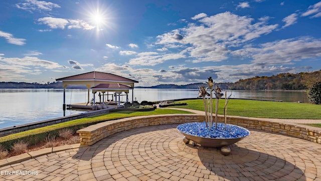 view of patio with a water view and a boat dock