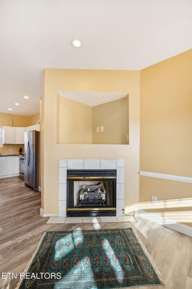 room details featuring a fireplace, stainless steel appliances, and hardwood / wood-style flooring