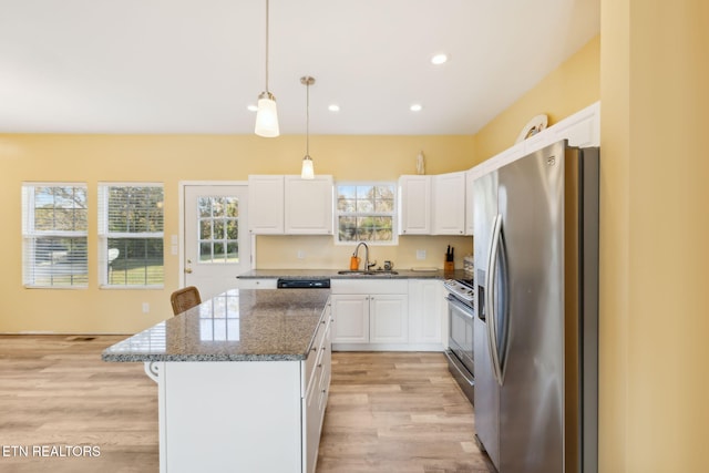 kitchen with white cabinetry, sink, stainless steel appliances, light hardwood / wood-style flooring, and dark stone counters