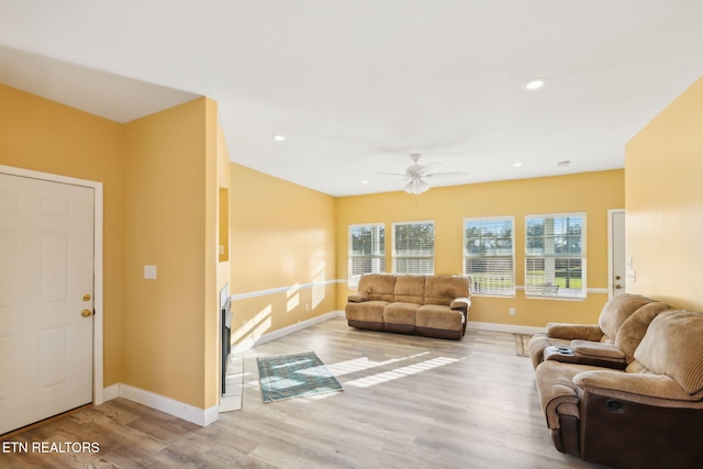 living room featuring light hardwood / wood-style floors and ceiling fan