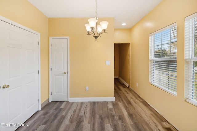 unfurnished room featuring dark hardwood / wood-style floors and a notable chandelier