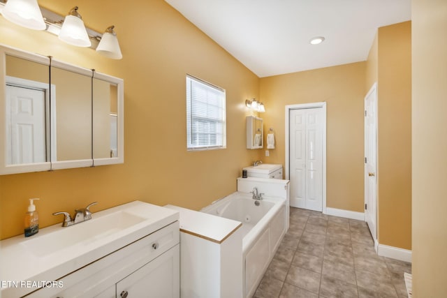 bathroom featuring tile patterned floors, a bathtub, and vanity