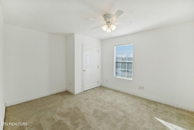 carpeted spare room with ceiling fan