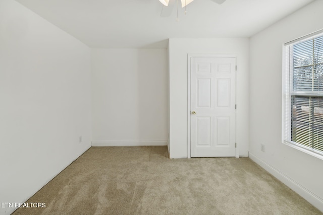 carpeted spare room with ceiling fan