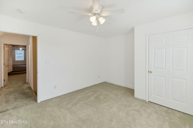 unfurnished room with light colored carpet and ceiling fan