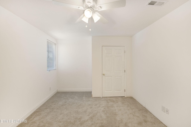 spare room featuring light colored carpet and ceiling fan