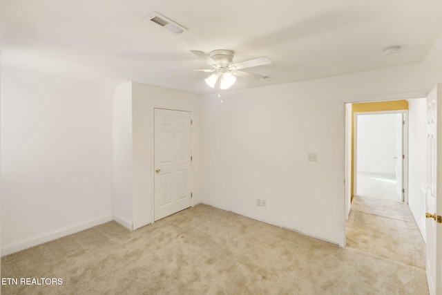 empty room featuring ceiling fan and light colored carpet