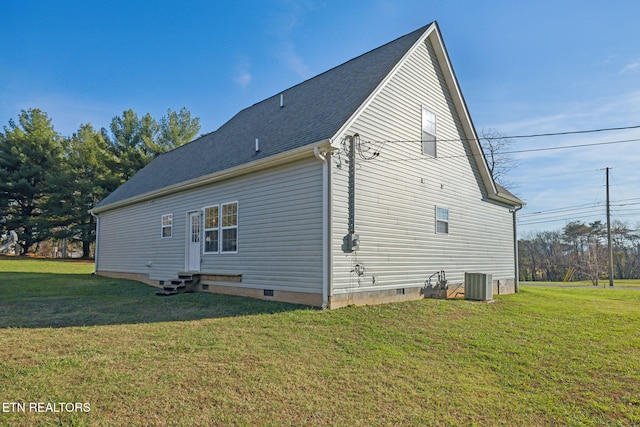 view of side of property with central air condition unit and a lawn