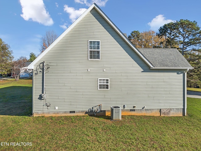 view of side of property with a lawn and central AC unit