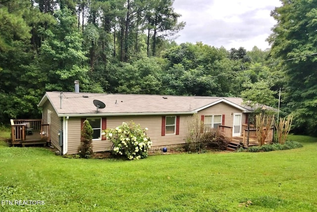 rear view of house with a lawn and a deck