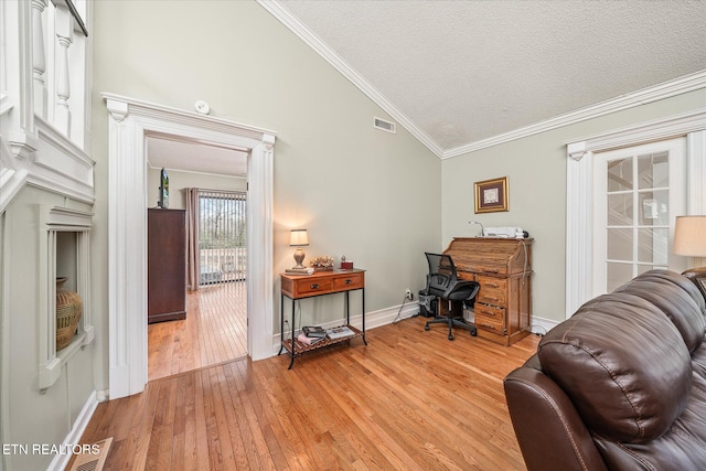 home office with a textured ceiling, ornamental molding, vaulted ceiling, and light hardwood / wood-style flooring